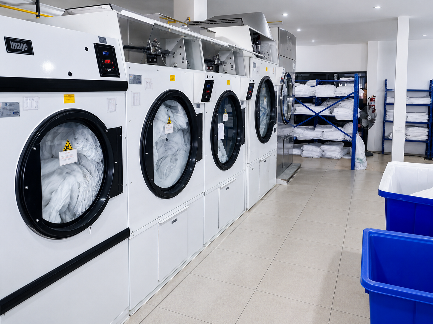 Industrial dryers and folded hotel linen at the Concept Laundry facility